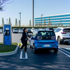 woman charging an electric vehicle at work