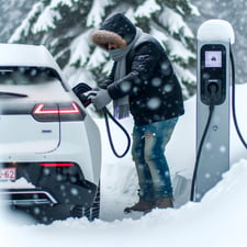 man charging an ev in the winter